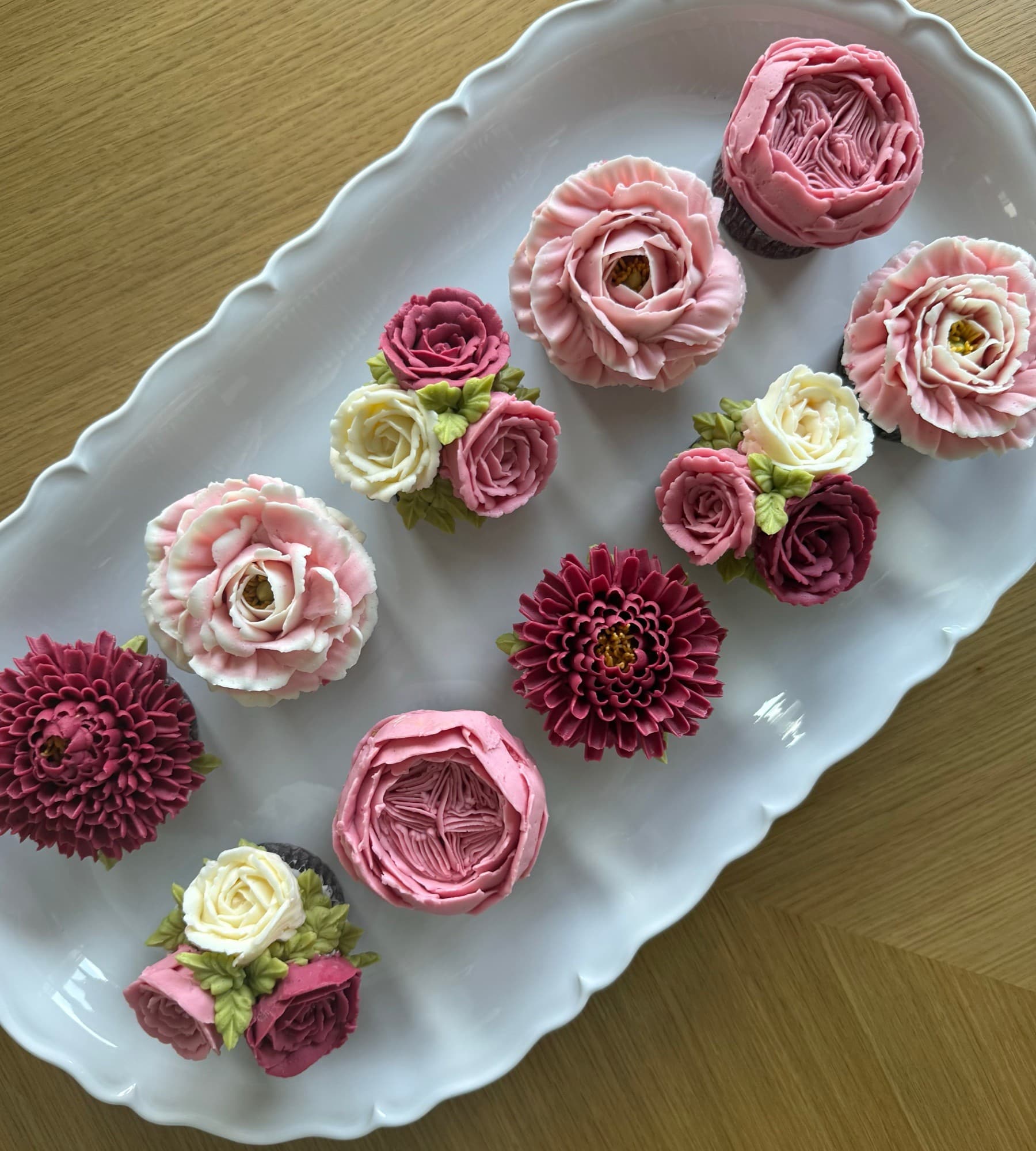 Pink roses, burgundy chrysanthemums and miniature ivory roses on a white serving platter