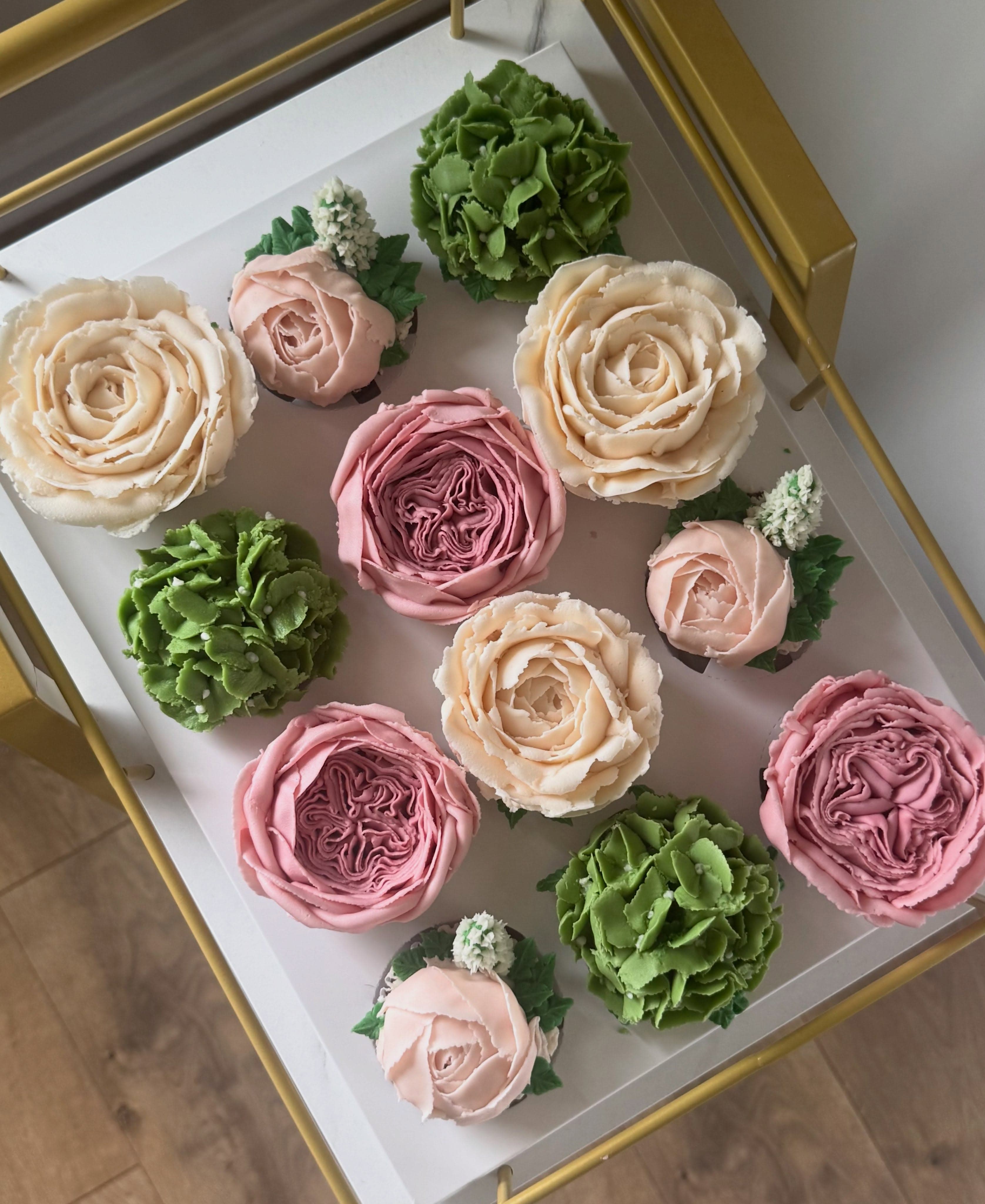 A dozen peach and pink roses with green hydrangea accents, boxed on a gold cart
